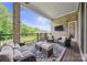 Relaxing covered outdoor patio with comfortable seating, TV, and serene backyard views at 1702 Batson Creek Ln, Weddington, NC 28104