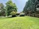 Quaint home surrounded by mature trees and a lush green lawn at 1733 S Nc 16 Business Hwy, Stanley, NC 28164