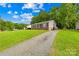 Quaint single-story home with a long driveway and well-maintained lawn, set against a backdrop of mature trees at 1812 Alpine Dr, Kings Mountain, NC 28086