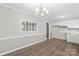 Bright kitchen features white cabinets, wood-look flooring, a window, and a view into the dining area at 1812 Alpine Dr, Kings Mountain, NC 28086
