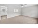 Cozy living room with neutral carpet, a ceiling fan, access to kitchen, and a bright window at 1812 Alpine Dr, Kings Mountain, NC 28086