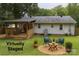This virtually staged backyard features a deck, patio, yard with green grass and mature trees at 2015 Downey St, Rock Hill, SC 29732