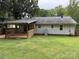 Large backyard with a wooden deck, a well-maintained lawn, and privacy fencing, perfect for outdoor living at 2015 Downey St, Rock Hill, SC 29732
