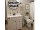 This virtually staged bathroom features a black faucet, black trimmed mirror, white vanity, toilet and tiled floor at 2015 Downey St, Rock Hill, SC 29732