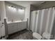Bathroom with double sink vanity, modern lighting, and shower with a white curtain at 2015 Downey St, Rock Hill, SC 29732
