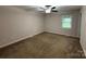 Carpeted bedroom features a ceiling fan and a window, with neutral colored walls at 2015 Downey St, Rock Hill, SC 29732