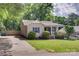 Charming home boasts curb appeal with lush greenery and a welcoming front porch at 203 Lincoln St, Belmont, NC 28012