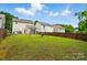 Well-maintained backyard with a swing set, a wooden fence, and neighboring homes, perfect for Gathering activities at 2234 Dion Ave, Charlotte, NC 28212