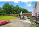 Fenced backyard with patio, green grass, mature trees, play set, and an umbrella for shade at 2234 Dion Ave, Charlotte, NC 28212