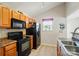 Kitchen featuring sleek black appliances and warm wood cabinetry at 2234 Dion Ave, Charlotte, NC 28212