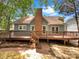 Back exterior view of home with brick chimney, wooden deck, and a well-maintained yard at 2312 Christensens Ct, Charlotte, NC 28270