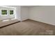 Bright, carpeted room featuring two sunlit windows, and fresh paint at 2312 Christensens Ct, Charlotte, NC 28270