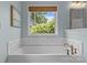 Bright bathroom featuring a luxurious soaking tub with stylish fixtures and a window overlooking lush greenery at 2315 Winthrop Ave, Charlotte, NC 28203