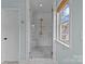 Modern bathroom featuring a glass-enclosed shower with white subway tile and marble-look tile flooring at 2315 Winthrop Ave, Charlotte, NC 28203