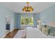 Light blue bedroom featuring large window, bench, lamps, and a decorative light fixture at 2315 Winthrop Ave, Charlotte, NC 28203