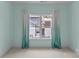 Light-filled bedroom with neutral carpet and window with sheer, teal-colored curtains at 2315 Winthrop Ave, Charlotte, NC 28203