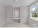 Cozy bedroom with pink walls, two closets and a window seat for relaxing and enjoying natural light at 2315 Winthrop Ave, Charlotte, NC 28203