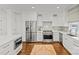 Modern kitchen with stainless steel appliances, white cabinets, and beautiful hardwood flooring at 2315 Winthrop Ave, Charlotte, NC 28203