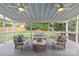 Relaxing outdoor patio with comfortable seating and ceiling fans overlooking landscaped backyard at 2315 Winthrop Ave, Charlotte, NC 28203