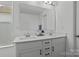 Bathroom featuring double vanity, white cabinets, and large mirror at 3127 Pinehills Way, Mount Holly, NC 28120