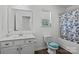 Neat bathroom featuring a tiled tub and shower, a vanity with sink and a window at 3127 Pinehills Way, Mount Holly, NC 28120