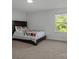 Bright bedroom features a comfortable bed, neutral carpet, and a large window at 3127 Pinehills Way, Mount Holly, NC 28120