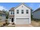 Charming two-story home featuring white siding, an attached garage, and well-maintained landscaping at 3127 Pinehills Way, Mount Holly, NC 28120