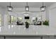 Bright open-concept living room with modern lighting and beautiful views from the kitchen island at 3127 Pinehills Way, Mount Holly, NC 28120