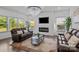 Spacious living room featuring a modern fireplace, large windows, and a stylish chandelier at 3127 Pinehills Way, Mount Holly, NC 28120