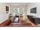 Cozy living area with a leather sofa, hardwood floors, and a view of the outdoors from the window at 314 Viburnum Way Ct, Charlotte, NC 28208