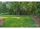 Lush green backyard surrounded by mature trees, offering ample space for recreation and relaxation at 3327 Lakeside Dr, Charlotte, NC 28270