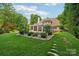 Landscaped backyard featuring a pool, spa, and lush greenery, creating a private oasis at 3327 Lakeside Dr, Charlotte, NC 28270