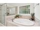 Luxurious bathroom featuring a soaking tub, glass shower, and tiled walls at 3327 Lakeside Dr, Charlotte, NC 28270