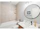 Bright bathroom featuring a tub/shower combo, round mirror, and a modern vanity at 3327 Lakeside Dr, Charlotte, NC 28270