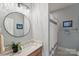 Bathroom features a modern vanity, stylish mirror, updated light fixture, and tiled shower with framed art at 3327 Lakeside Dr, Charlotte, NC 28270