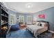 Comfortable bedroom featuring blue accent walls, a blue rug, and windows with white shutters at 3327 Lakeside Dr, Charlotte, NC 28270
