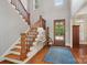 Bright foyer with hardwood floors, staircase, natural wood door and blue patterned rug at 3327 Lakeside Dr, Charlotte, NC 28270