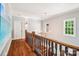 Upstairs hallway featuring hardwood floors, wainscoting, and elegant chandelier at 3327 Lakeside Dr, Charlotte, NC 28270