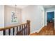 Upstairs hallway featuring hardwood floors and a view from the window at 3327 Lakeside Dr, Charlotte, NC 28270