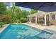 Relaxing pool view with a lounge area, basketball hoop, and umbrella for shade. Outdoor kitchen in background at 3327 Lakeside Dr, Charlotte, NC 28270