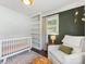 Bright Bedroom featuring a white crib, comfortable seating, and natural light at 3530 Woodleaf Rd, Charlotte, NC 28205