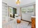 Charming bedroom with a crib, white armchair, woven light fixture, and stylish decorative touches at 3530 Woodleaf Rd, Charlotte, NC 28205