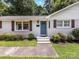 Inviting front door with steps, fresh landscaping, and contrasting brown shutters on a sunny day at 3530 Woodleaf Rd, Charlotte, NC 28205