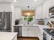 Modern kitchen with white cabinets, subway tile backsplash, stainless steel appliances, and hardwood floors at 3530 Woodleaf Rd, Charlotte, NC 28205