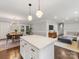 Bright, open kitchen with a large island, pendant lighting, and hardwood floors flowing into the dining and living area at 3530 Woodleaf Rd, Charlotte, NC 28205