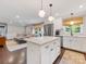Open concept kitchen with a view into the living room, featuring white cabinets and a large island at 3530 Woodleaf Rd, Charlotte, NC 28205