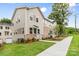 A view of the townhouse featuring manicured lawns, mulched flower beds, and a concrete walkway at 3924 Hager Dr, Charlotte, NC 28208
