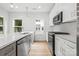Modern kitchen features white cabinets, stainless steel appliances, and an island with a quartz countertop at 3924 Hager Dr, Charlotte, NC 28208