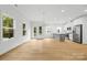 Spacious living room showcasing natural light, modern lighting, and sleek, light-colored hardwood floors at 3924 Hager Dr, Charlotte, NC 28208