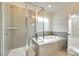 Spa-like bathroom features a glass-enclosed shower, a soaking tub, and tiled walls, creating a luxurious retreat at 4051 Whittier Ln, Fort Mill, SC 29708